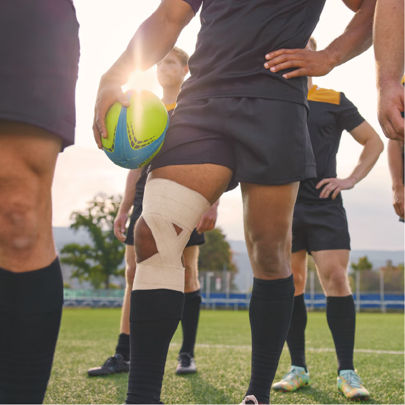 Tensoplast application sur le genou d'un rugbyman