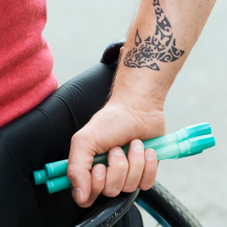 Speedicath compact homme tenu dans la main d'un homme en fauteuil roulant